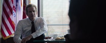 Movie still from “Sicario: Day of the Soldado” (2018), directed by Stefano Sollima – A man sitting at a table in front of a window; Medium shot, Over the shoulder angle