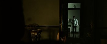 Movie still from “Sicario: Day of the Soldado” (2018), directed by Stefano Sollima – A man standing in a room in front of an open door; Wide shot, Over the shoulder angle