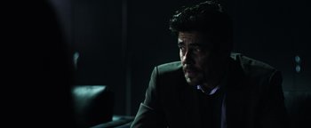 Movie still from “Sicario: Day of the Soldado” (2018), directed by Stefano Sollima – A person wearing a suit and tie; Close Up shot, Over the shoulder angle