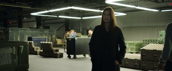 Movie still from “Sicario: Day of the Soldado” (2018), directed by Stefano Sollima – A woman standing in an industrial setting with a bunch of people in the background; Medium shot, Low angle