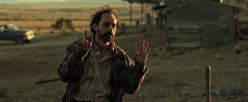 Movie still from “Sicario: Day of the Soldado” (2018), directed by Stefano Sollima – A man with a beard is holding up his fingers; Medium shot, Over the shoulder angle