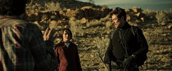 Movie still from “Sicario: Day of the Soldado” (2018), directed by Stefano Sollima – A man and a woman standing on a rocky hillside; Medium shot, Over the shoulder angle