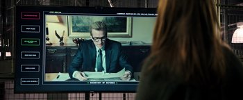 Movie still from “Sicario: Day of the Soldado” (2018), directed by Stefano Sollima – A man sitting at a table in front of a television; Medium shot, Over the shoulder angle