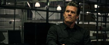 Movie still from “Sicario: Day of the Soldado” (2018), directed by Stefano Sollima – A man in black shirt sitting in front of a window; Close Up shot, Low angle