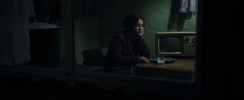 Movie still from “Sicario: Day of the Soldado” (2018), directed by Stefano Sollima – A woman sitting at a table in front of a computer monitor; Medium shot, High angle