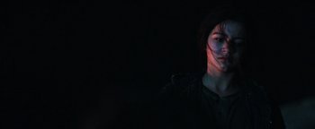 Movie still from “Sicario: Day of the Soldado” (2018), directed by Stefano Sollima – A woman is smiling in the dark with her eyes closed; Close Up shot, Over the shoulder angle