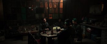 Movie still from “Sicario: Day of the Soldado” (2018), directed by Stefano Sollima – A group of men sitting at a table in front of a window; Medium shot, High angle