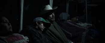 Movie still from “Sicario: Day of the Soldado” (2018), directed by Stefano Sollima – A man and a boy sitting next to each other on a train; Medium shot, High angle
