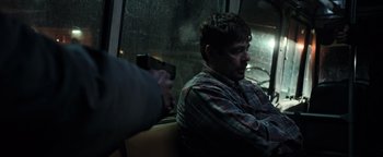Movie still from “Sicario: Day of the Soldado” (2018), directed by Stefano Sollima – A man holding a gun while sitting on a bus; Medium shot, Over the shoulder angle