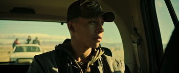 Movie still from “Sicario: Day of the Soldado” (2018), directed by Stefano Sollima – A man in a cap and jacket looking out a window; Close Up shot, Low angle