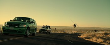 Movie still from “Sicario: Day of the Soldado” (2018), directed by Stefano Sollima – A group of people riding in a car on a road; Wide shot, Low angle