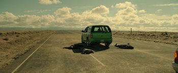 Movie still from “Sicario: Day of the Soldado” (2018), directed by Stefano Sollima – A car parked on the side of the road next to two dead bodies on the ground; Wide shot, High angle