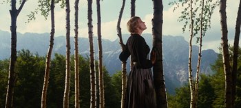 Movie still from “The Sound of Music” (1965), directed by Robert Wise – A woman standing next to a tree in the woods; Wide shot, Low angle