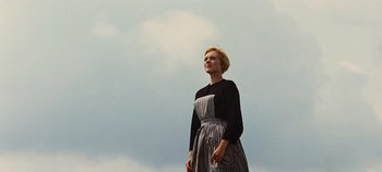 Movie still from “The Sound of Music” (1965), directed by Robert Wise – A woman standing in front of a cloudy blue sky; Medium shot, Low angle