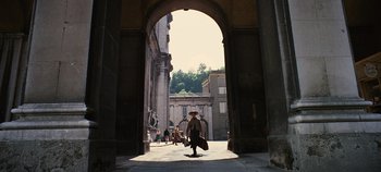Movie still from “The Sound of Music” (1965), directed by Robert Wise – A woman walking down a street holding a bag; Extreme Wide shot, Low angle
