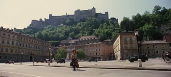 Movie still from “The Sound of Music” (1965), directed by Robert Wise – A man riding a scooter down the street in front of a castle; Extreme Wide shot, Low angle