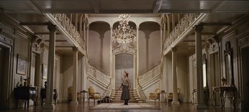 Movie still from “The Sound of Music” (1965), directed by Robert Wise – A woman standing in front of a grand staircase; Extreme Wide shot, Low angle
