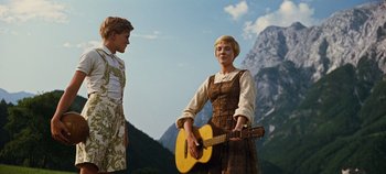 Movie still from “The Sound of Music” (1965), directed by Robert Wise – A man and a woman standing next to each other holding a guitar; Medium shot, Low angle
