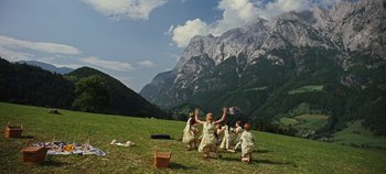 Movie still from “The Sound of Music” (1965), directed by Robert Wise – A group of people standing on top of a grass covered field; Extreme Wide shot, High angle