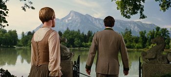 Movie still from “The Sound of Music” (1965), directed by Robert Wise – Two people are standing near a body of water; Medium shot, Over the shoulder angle