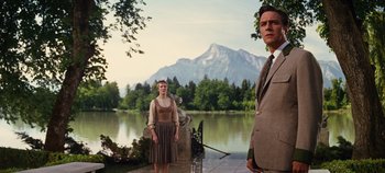 Movie still from “The Sound of Music” (1965), directed by Robert Wise – A man and a woman standing in front of a body of water; Medium shot, Low angle