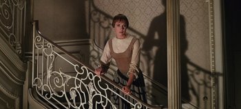 Movie still from “The Sound of Music” (1965), directed by Robert Wise – A woman in a dress standing at the top of a stair railing; Medium shot, Low angle