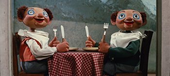 Movie still from “The Sound of Music” (1965), directed by Robert Wise – A couple of people sitting at a table holding forks; Medium shot, High angle