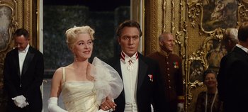 Movie still from “The Sound of Music” (1965), directed by Robert Wise – A man and a woman standing next to each other in formal wear; Medium shot, Low angle
