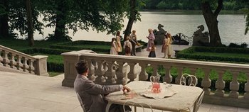 Movie still from “The Sound of Music” (1965), directed by Robert Wise – A man sitting at a table in front of a fountain; Wide shot, High angle
