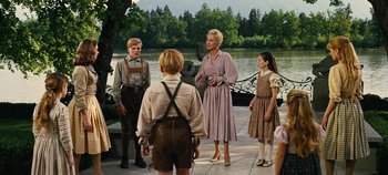 Movie still from “The Sound of Music” (1965), directed by Robert Wise – A group of people standing next to a body of water; Wide shot, Low angle