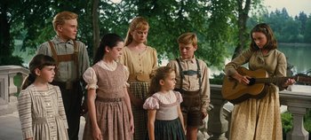 Movie still from “The Sound of Music” (1965), directed by Robert Wise – A group of people standing next to each other near a tree; Medium shot, Low angle