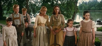 Movie still from “The Sound of Music” (1965), directed by Robert Wise – Two women and a little girl standing next to each other holding a guitar; Medium shot, Low angle