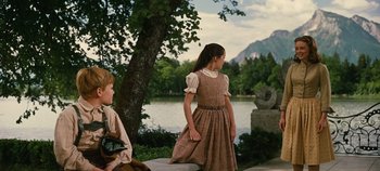 Movie still from “The Sound of Music” (1965), directed by Robert Wise – Two girls in dresses standing next to a body of water; Wide shot, Low angle