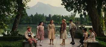 Movie still from “The Sound of Music” (1965), directed by Robert Wise – A group of people standing on a stone patio; Wide shot, Low angle