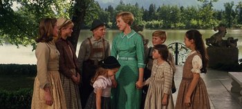 Movie still from “The Sound of Music” (1965), directed by Robert Wise – A group of people standing next to a body of water; Medium shot, Low angle