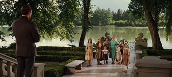 Movie still from “The Sound of Music” (1965), directed by Robert Wise – A group of people standing next to a body of water; Wide shot, Low angle