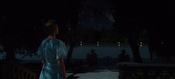 Movie still from “The Sound of Music” (1965), directed by Robert Wise – A woman standing in front of a body of water at night; Wide shot, High angle