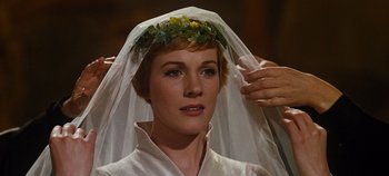 Movie still from “The Sound of Music” (1965), directed by Robert Wise – A woman wearing a veil and a flower crown; Close Up shot, Over the shoulder angle