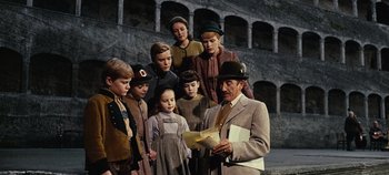 Movie still from “The Sound of Music” (1965), directed by Robert Wise – A group of people standing in front of an older man; Medium shot, Low angle