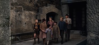 Movie still from “The Sound of Music” (1965), directed by Robert Wise – A group of people standing next to each other on a street; Wide shot, High angle