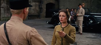 Movie still from “The Sound of Music” (1965), directed by Robert Wise – A woman holding a cell phone while standing next to a man; Medium shot, Over the shoulder angle