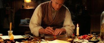 Movie still from “The Spiderwick Chronicles” (2008), directed by Mark Waters – An older man is working on a book; Medium shot, Low angle
