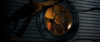 Movie still from “The Spiderwick Chronicles” (2008), directed by Mark Waters – A man is looking through a round window in a house; Close Up shot, Low angle