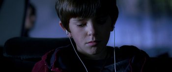 Movie still from “The Spiderwick Chronicles” (2008), directed by Mark Waters – A young boy wearing headphones looking down at his face; Close Up shot, High angle