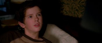 Movie still from “The Spiderwick Chronicles” (2008), directed by Mark Waters – A young boy sitting on a couch looking at the camera; Close Up shot, High angle