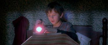 Movie still from “The Spiderwick Chronicles” (2008), directed by Mark Waters – A young boy is holding a flashlight in his hand; Medium shot, High angle