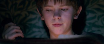 Movie still from “The Spiderwick Chronicles” (2008), directed by Mark Waters – A young boy is looking at the screen of a tablet; Close Up shot, Low angle