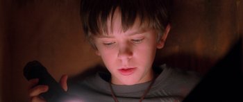 Movie still from “The Spiderwick Chronicles” (2008), directed by Mark Waters – A young boy is looking at his cell phone; Close Up shot, High angle