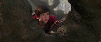 Movie still from “The Spiderwick Chronicles” (2008), directed by Mark Waters – A young boy in a red shirt climbing a tree; Close Up shot, Low angle