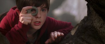 Movie still from “The Spiderwick Chronicles” (2008), directed by Mark Waters – A young boy is holding an object up to his eye; Close Up shot, High angle